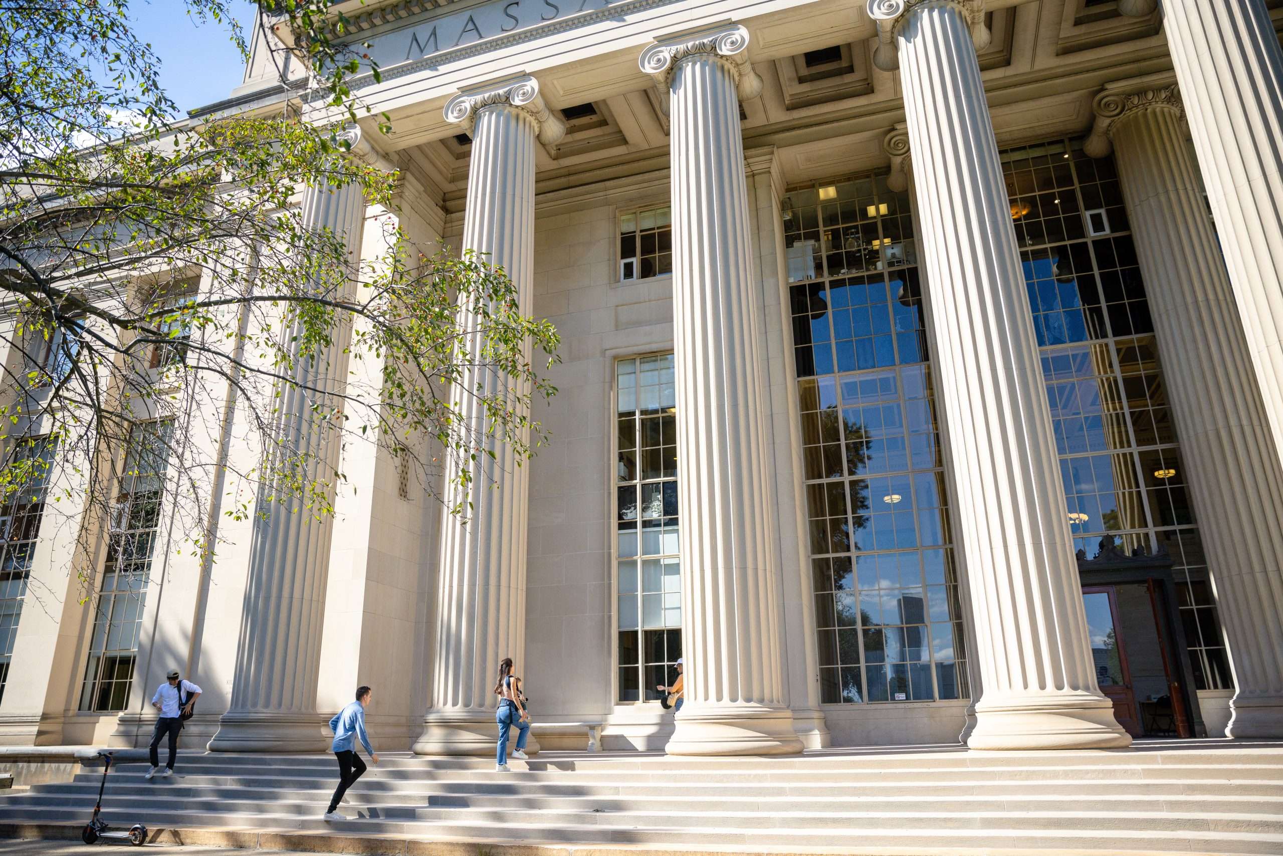 Students walk up the steps of a pillared building at the Massachusetts Institute of Technology.