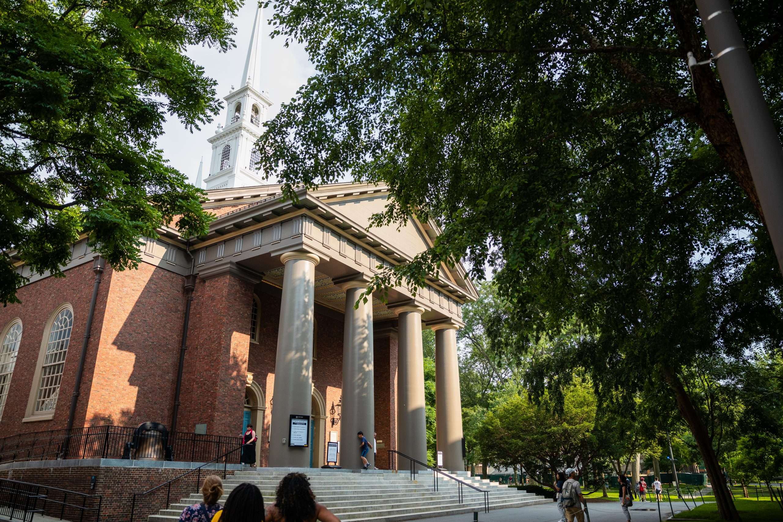 A columned building is featured beyond steps at Harvard University.