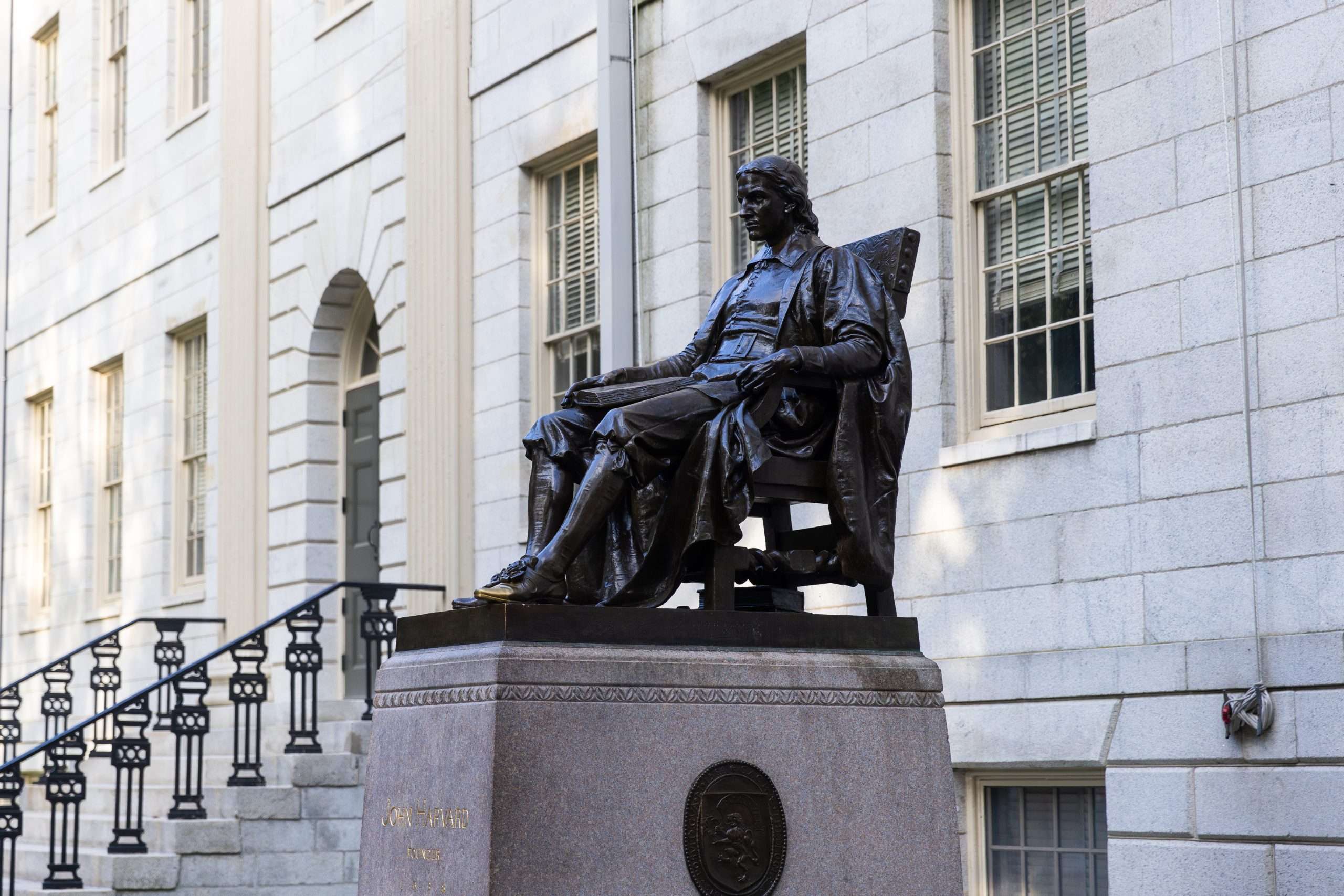 A side view of the John Harvard bronze statue at Harvard University.