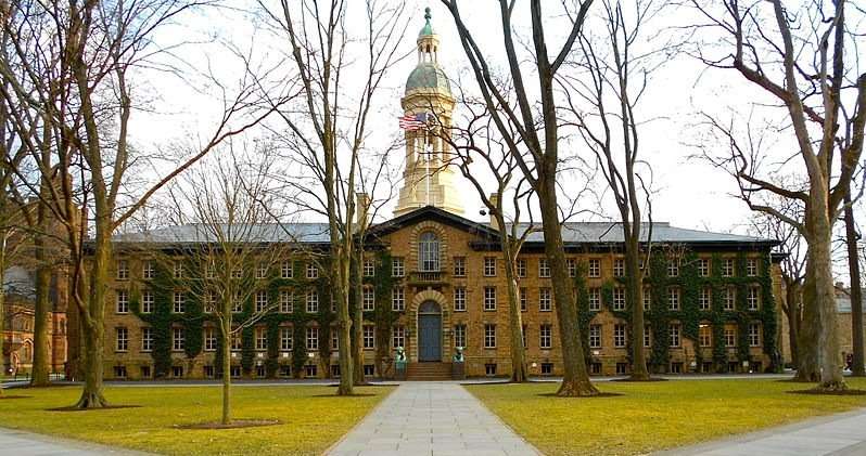 Nassau Hall is featured behind trees that have shed their leaves.