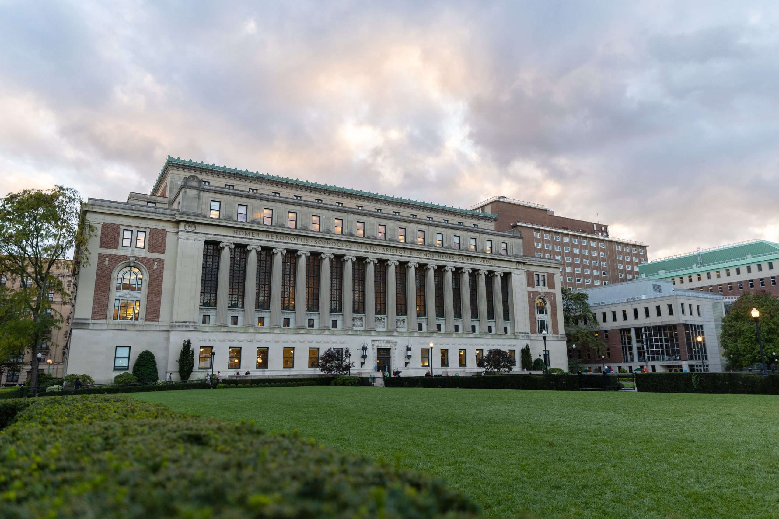 Columbia University's library is featured beyond a lawn.