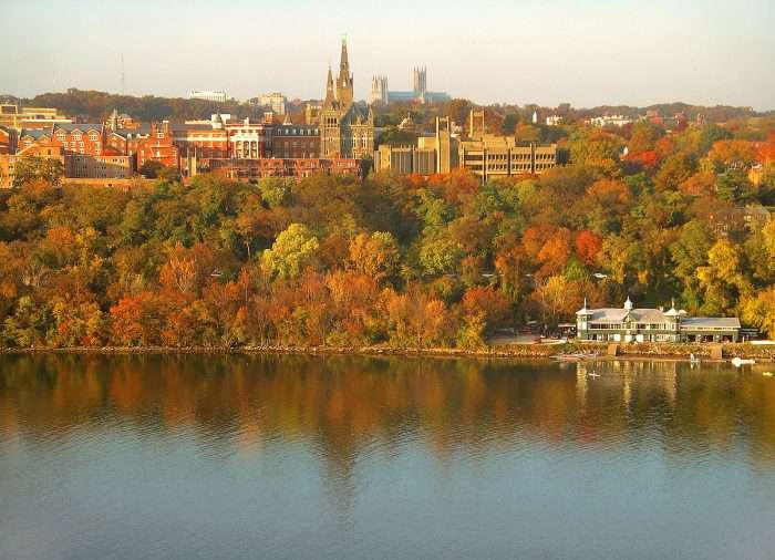 A college campus lies beyond a river.