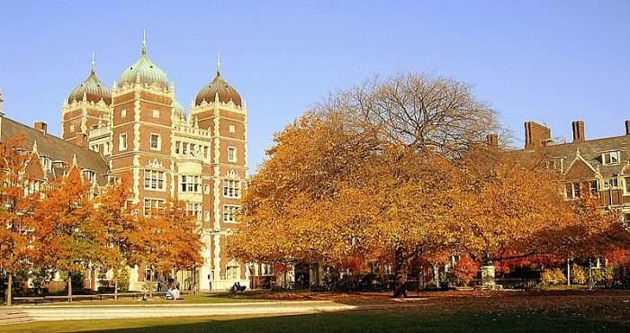 The University of Pennsylvania's quad is featured with orange trees on an autumn day.
