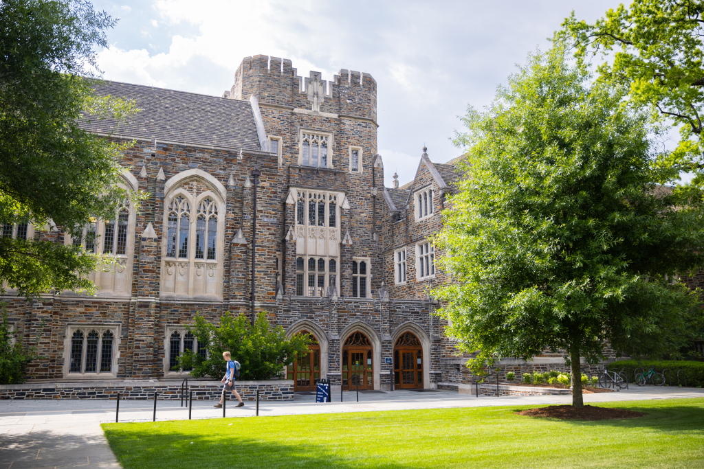 A man with a backpack walks in front of Duke Chapel at Duke University.